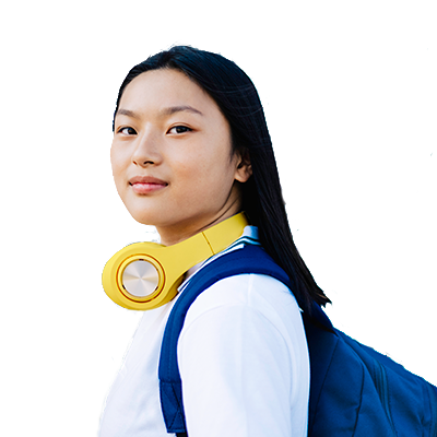 A young secondary student looking directly into the camera with headphones around her neck.